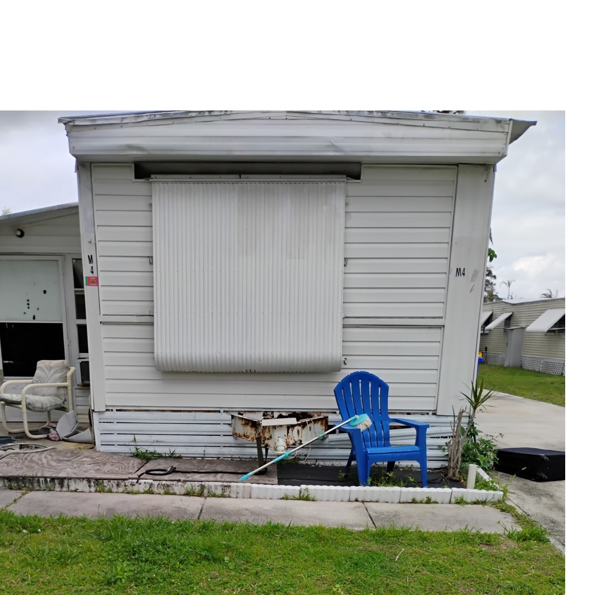Metal Modular Home Single-Story with Car Garage, White Siding, and Blue Door